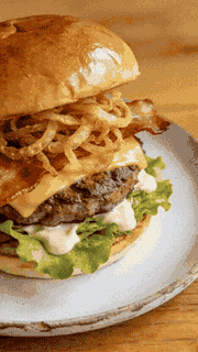 Smash burger with a fried egg on a dark wooden board